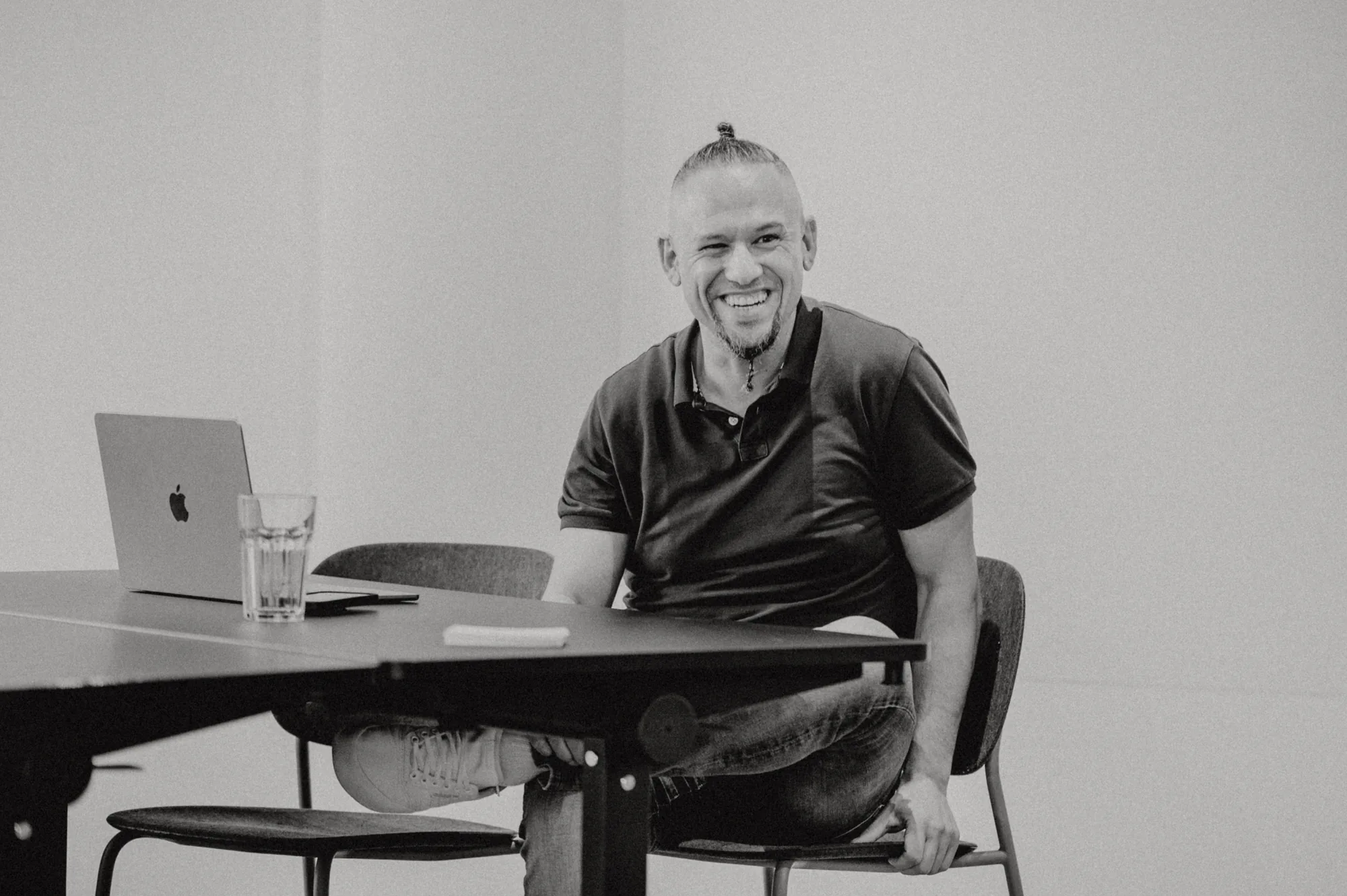 Andreas Schmitz, Host von BENE Unternehmer-Circle, am Tisch mit MacBook.